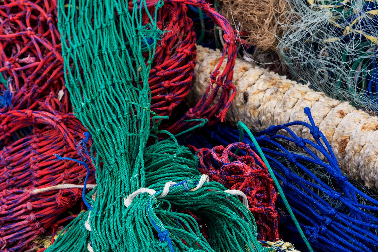Redes de pesca coloridas apiladas en el puerto